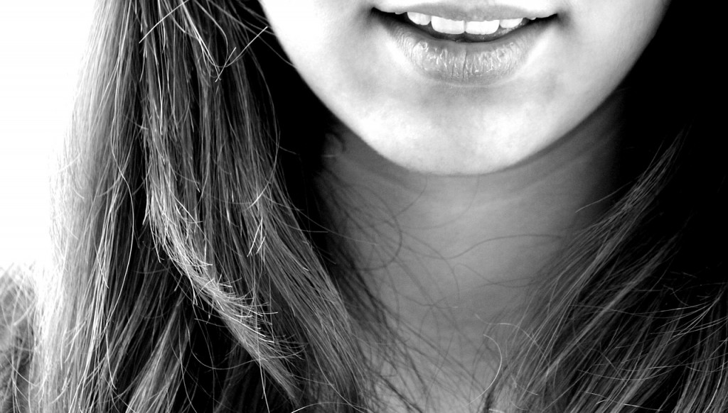 Somedays you need to be happy... That is all. A woman's mouth is visible and she is smiling, a black and white portrait. 