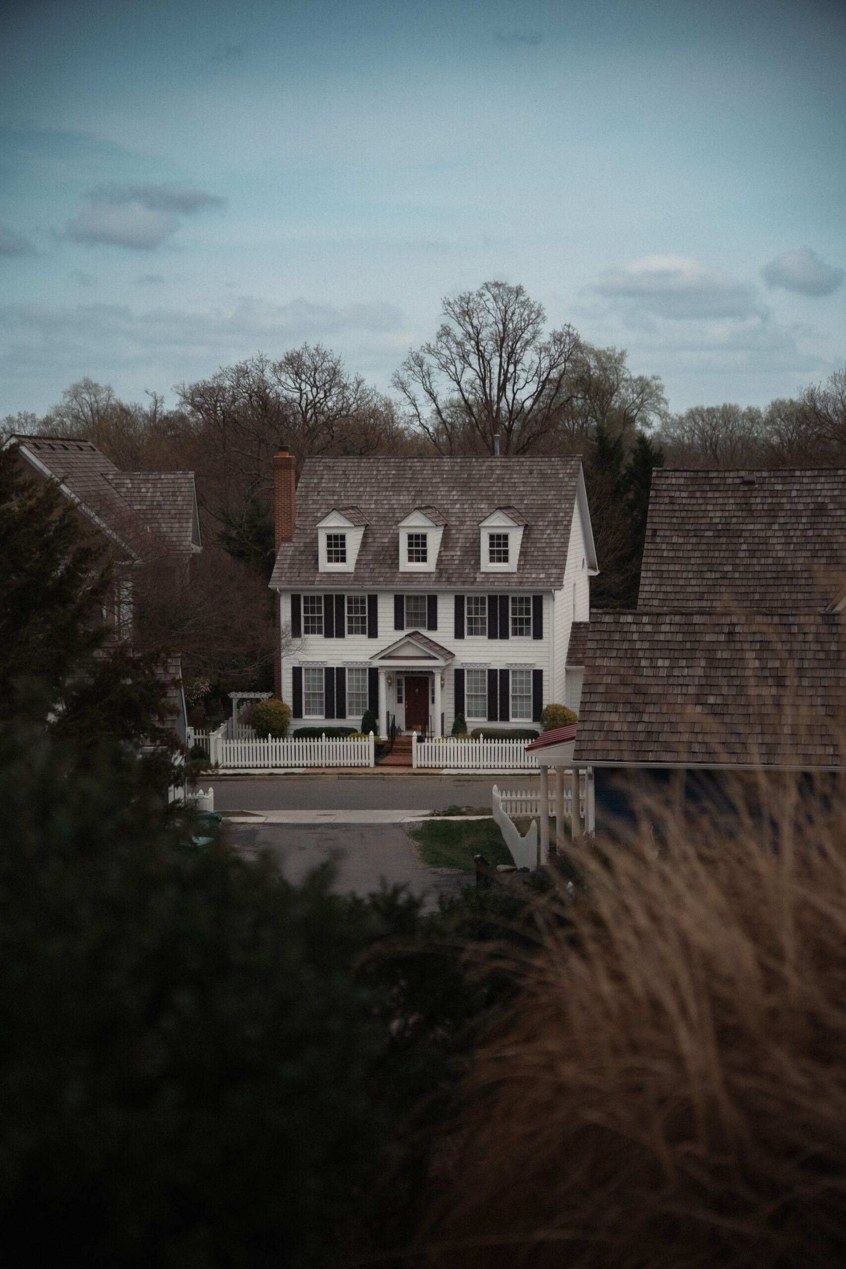 Dark foliage frame a lone, stoic, possibly haunted home. This article shares ghost stories and supernatural experiences in long term care facilities.