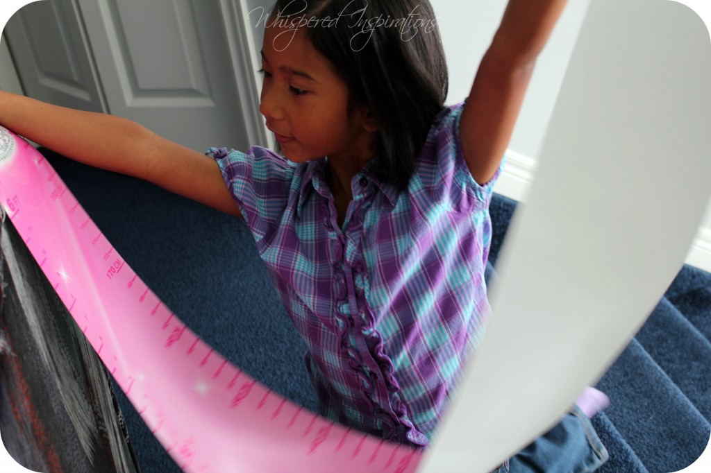 Gabby holds her new growth chart in the air. 