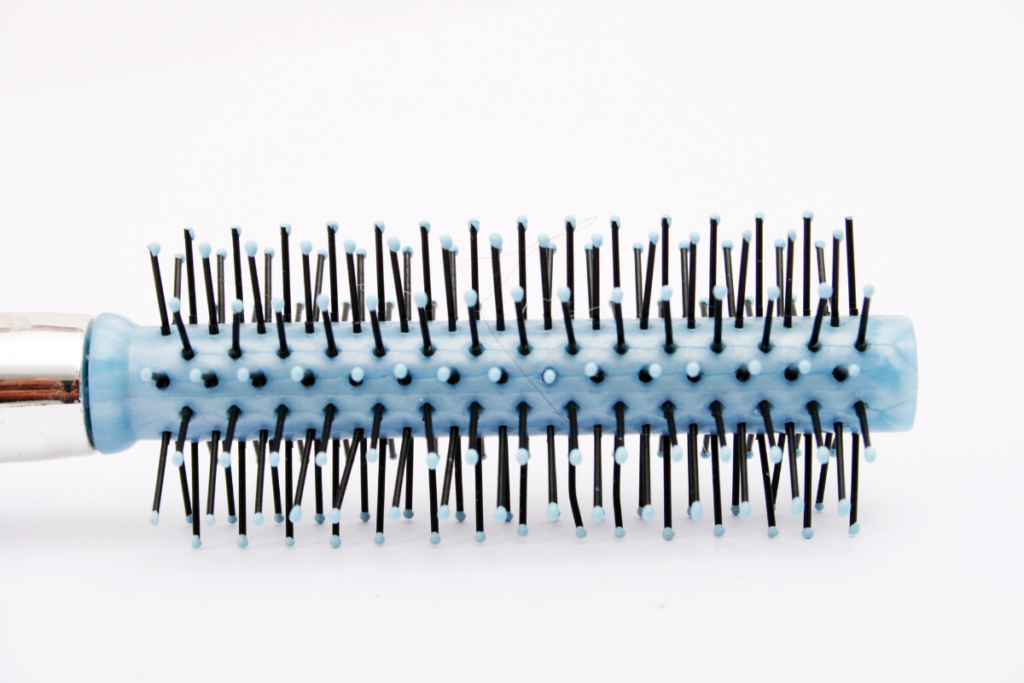 A blue and black brush against a white background. It is laying on its side.