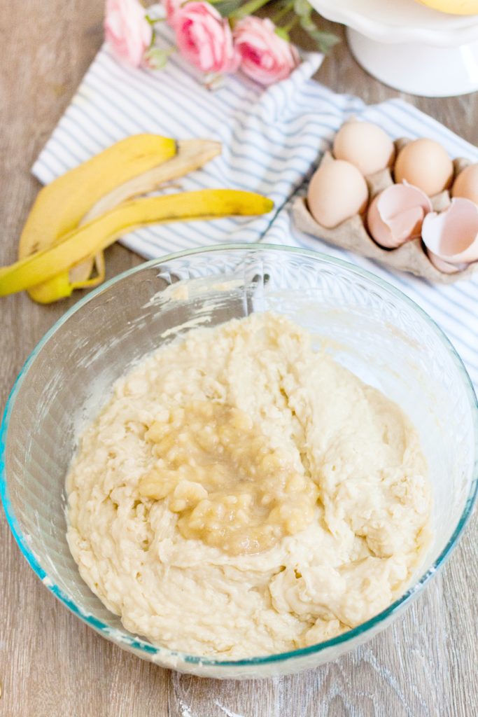 Banana mixture is added to batter in a mixing bowl.
