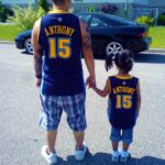 A little girl stands with her dad. 