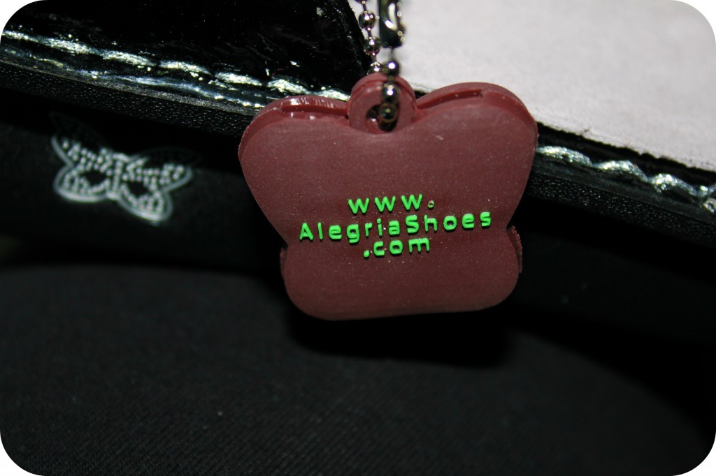 A close up of Alegria Shoes keychain is shown. 