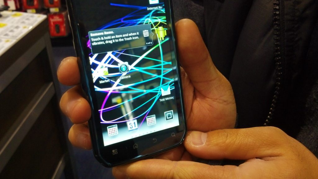 A man holds a Motorola Photon while browsing at Best Buy.