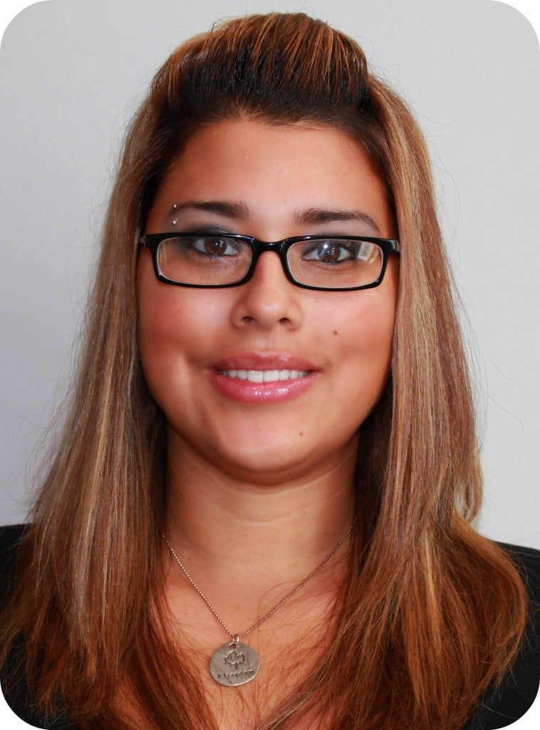 Woman smiles and shows off her new glasses. 