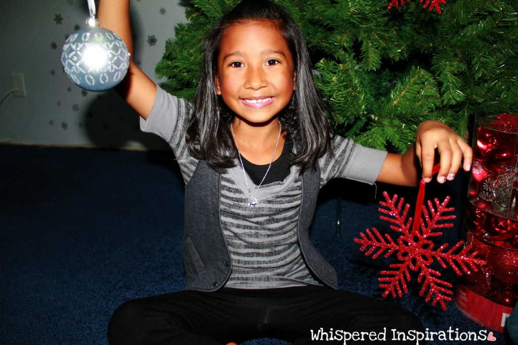 Little girl holds ornaments. 