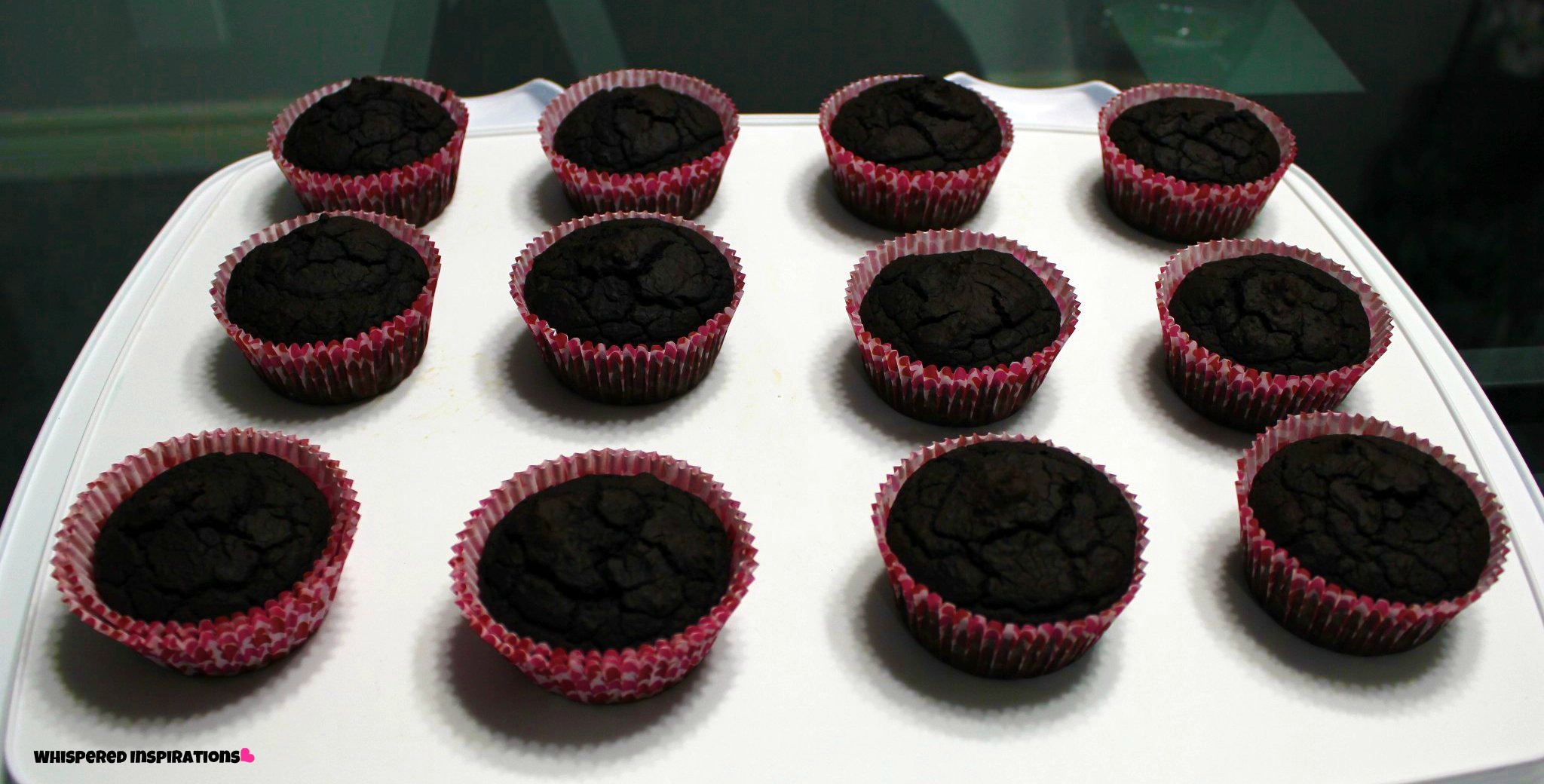 Chocolate cupcakes cooling on a tray.