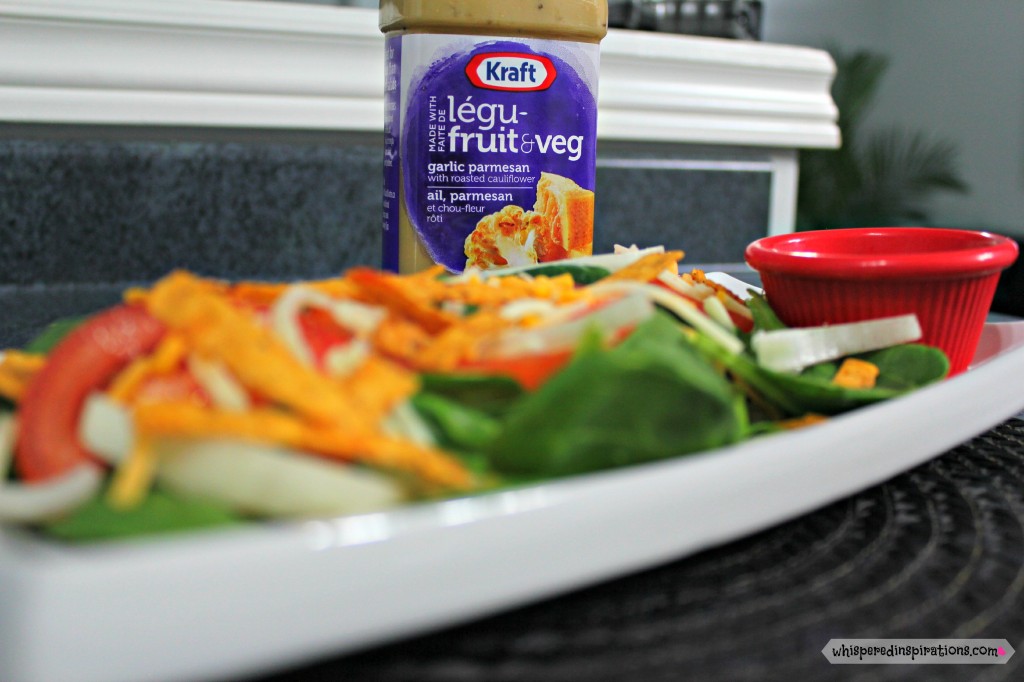 Skinny Spinach Salad is shown on a long plate with NEW Kraft Pourables dressing is in the background. 