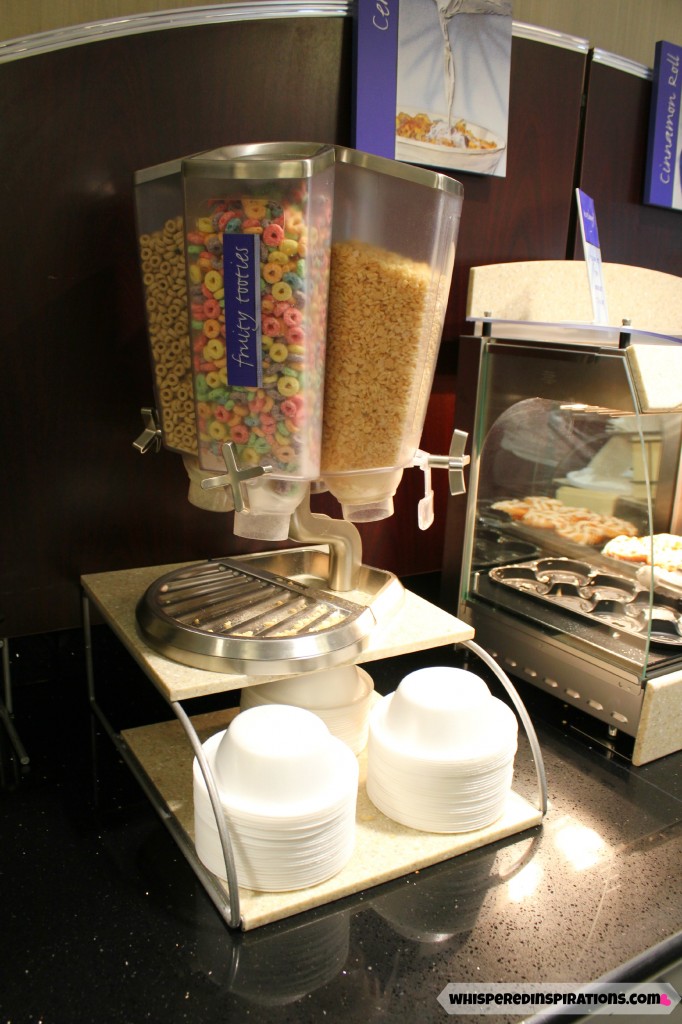 A cereal dispenser with Cheerios, Fruit Loops, and Rice Krispies at the Holiday Inn Breakfast bar. 