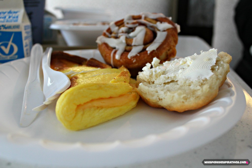 A plate of Holiday Inn Breakfast with eggs, biscuits, cinnamon rolls and more. 