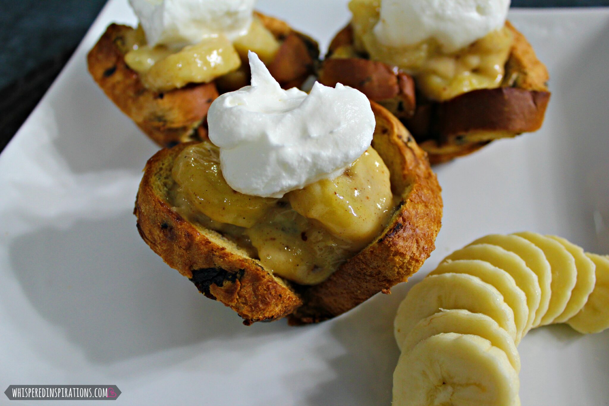 Close up of breakfast cups with banana foster filling and whipped cream.