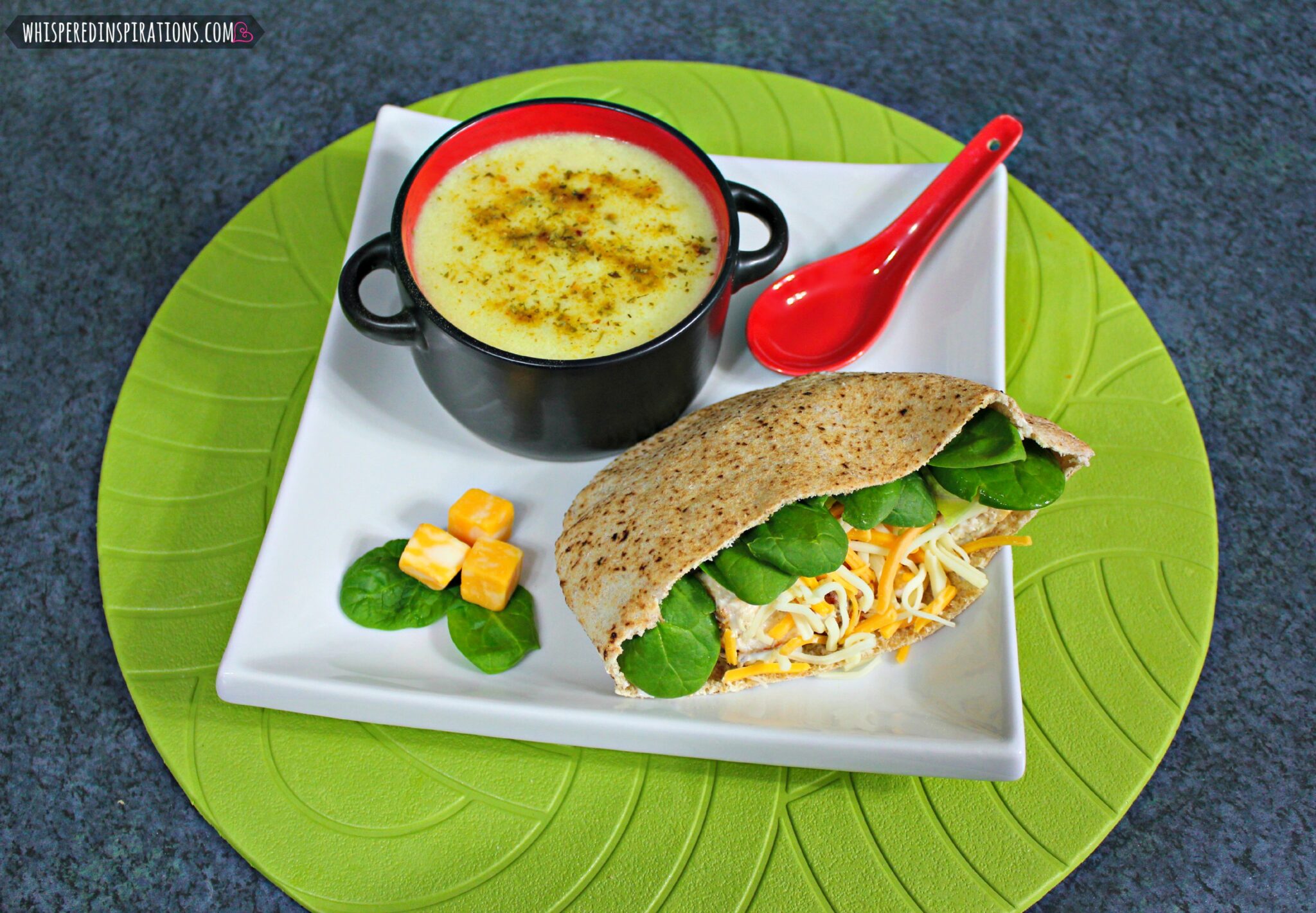 Chicken salad pita and potato soup are shown on a plate. 