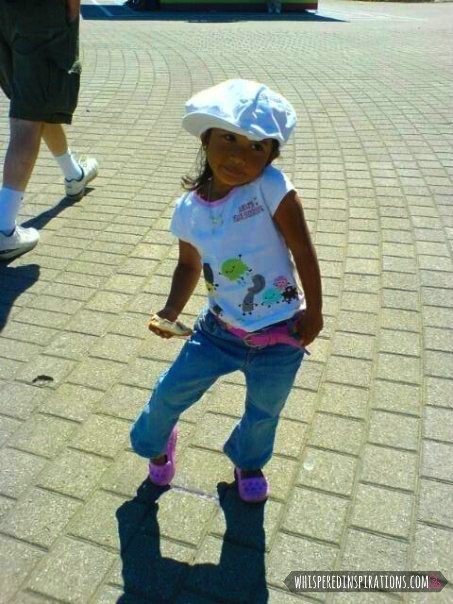 A little girl poses in a fashionable outfit. 