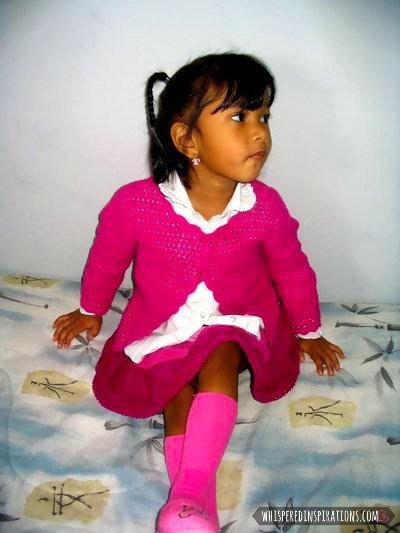 Little girl poses in a cute pink outfit. 