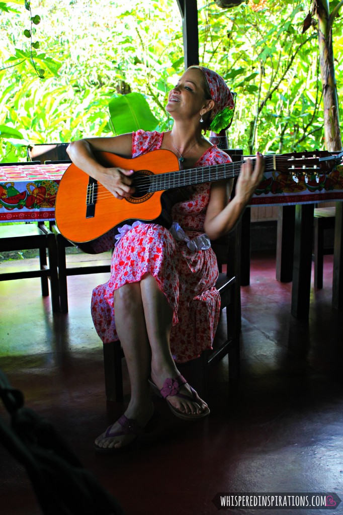 Woman playing guitar and singing joyfully. 
