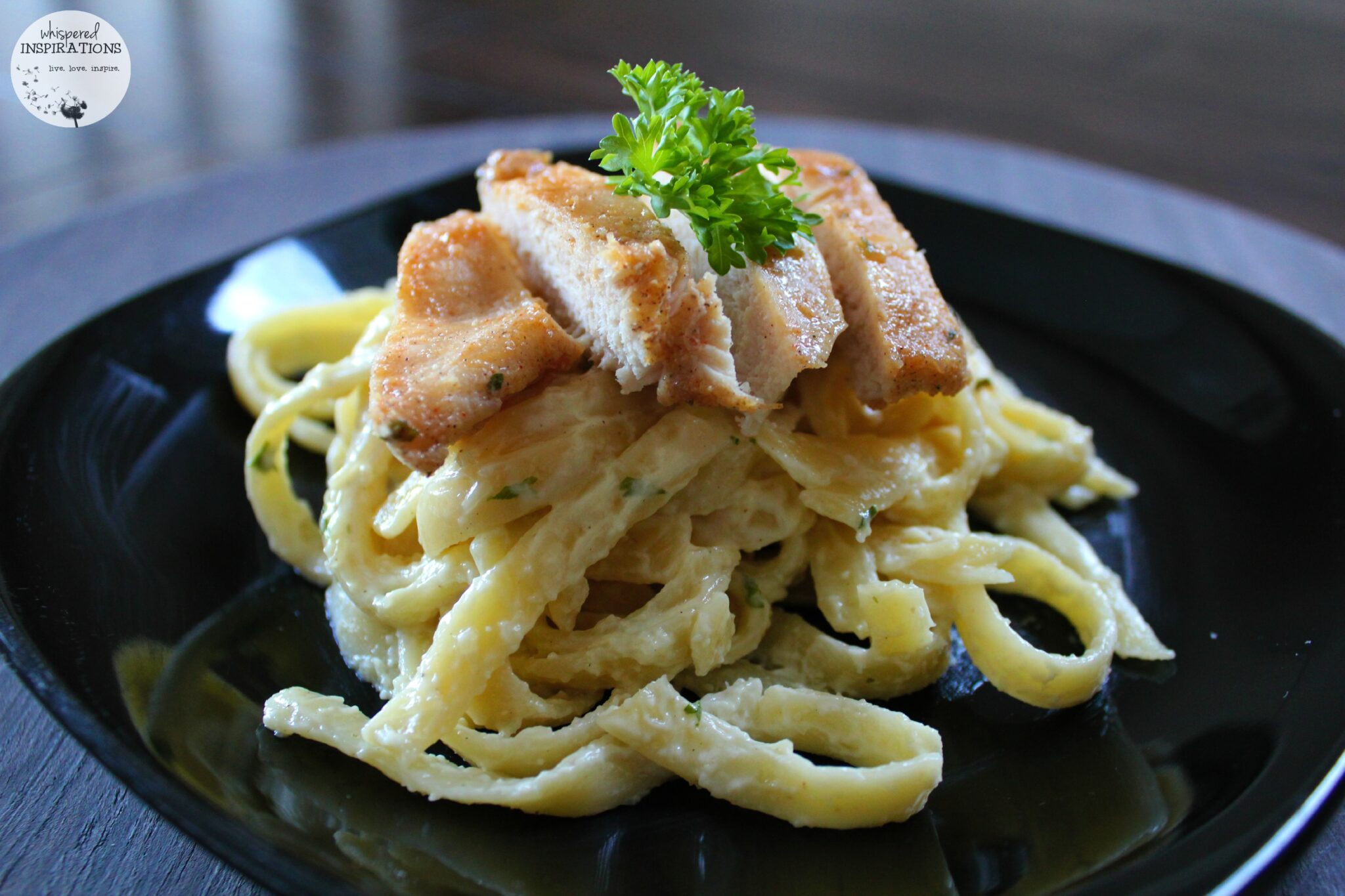 Delicious pan-friend chicken tops fettucine alfredo pasta. 
