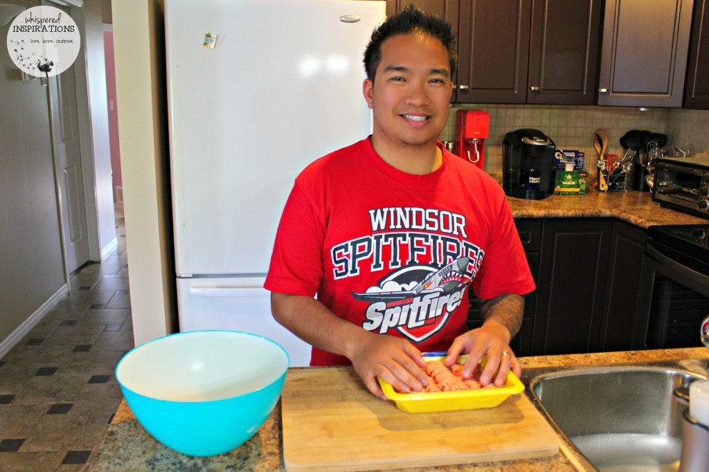 Darasak cooks and touches raw chicken on a board. 