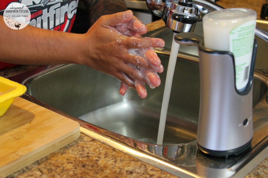 Darasak lathering the soap from the Lysol Dispenser. 