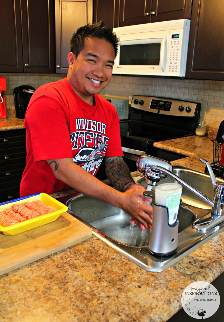 Darasak smiles as he finishes washing his hands at the sink. 