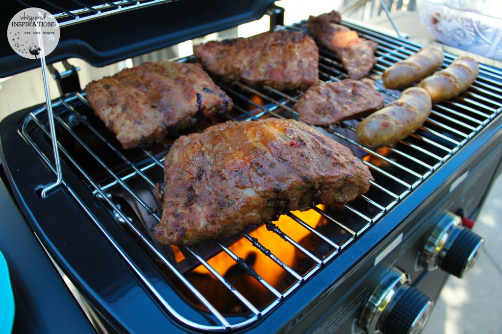 Ribs and sausages are grilling on the BBQ. 