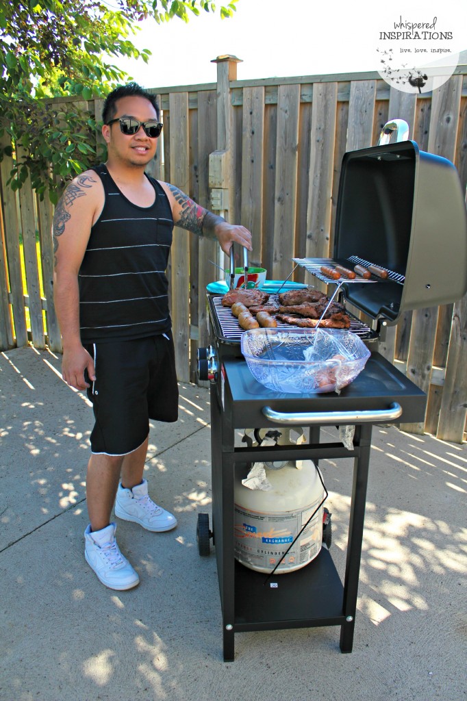 A man BBQ's sausages, ribs, and hot dogs. 