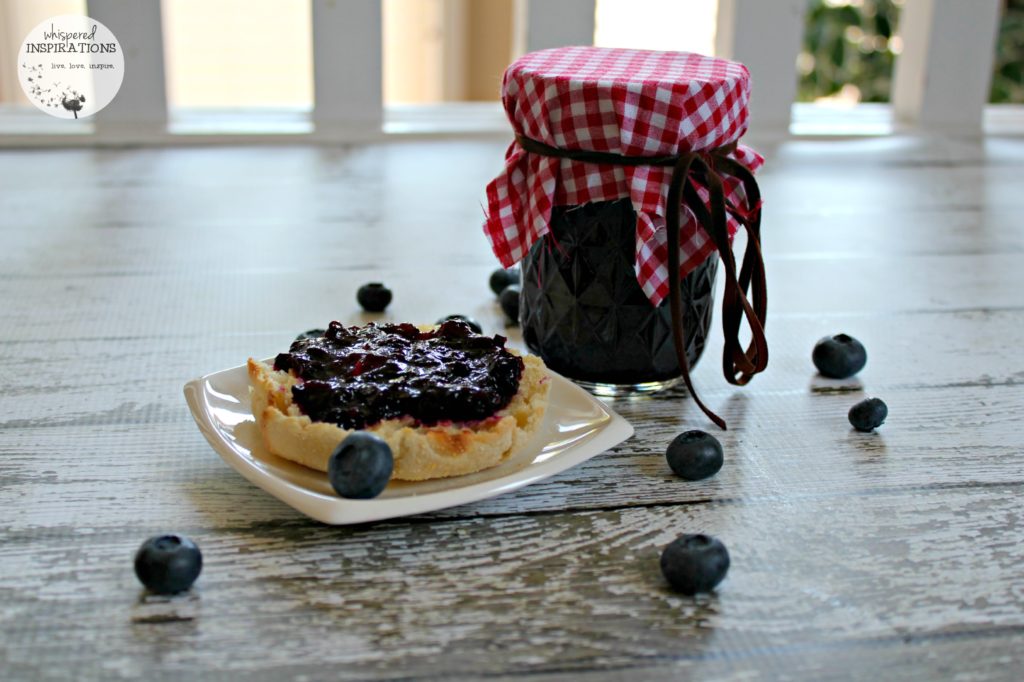 Organic blueberry jam recipe is spread on an English muffin. 