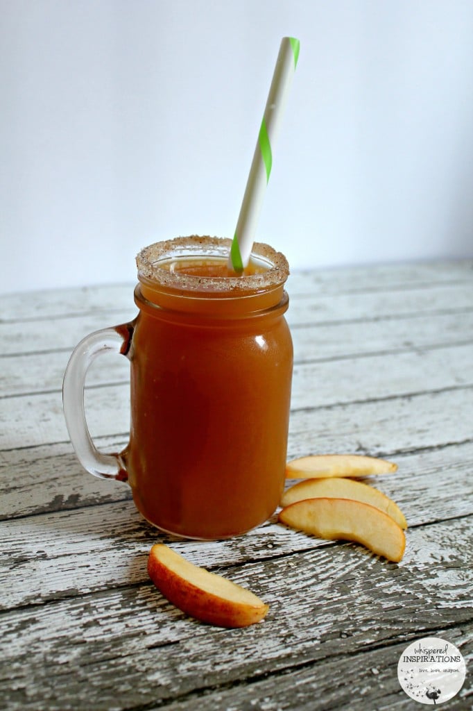 A Bernardin mason jar rimmed with sugar and cinnamon filled with apple cider and a large straw. 