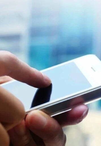 Hands holding a smart phone and tapping screen. This article shares the sharpest gadgets to get this holiday season.