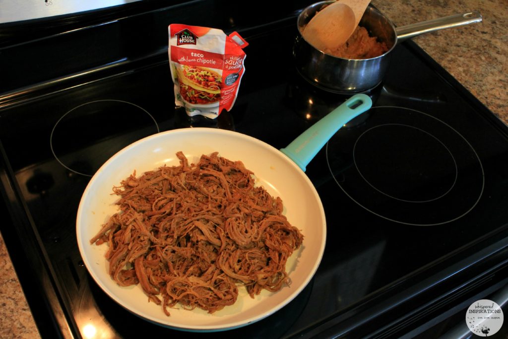 Shredded Beef in skillet with Taco with Chipotle Skillet Sauce about to be poured on. 