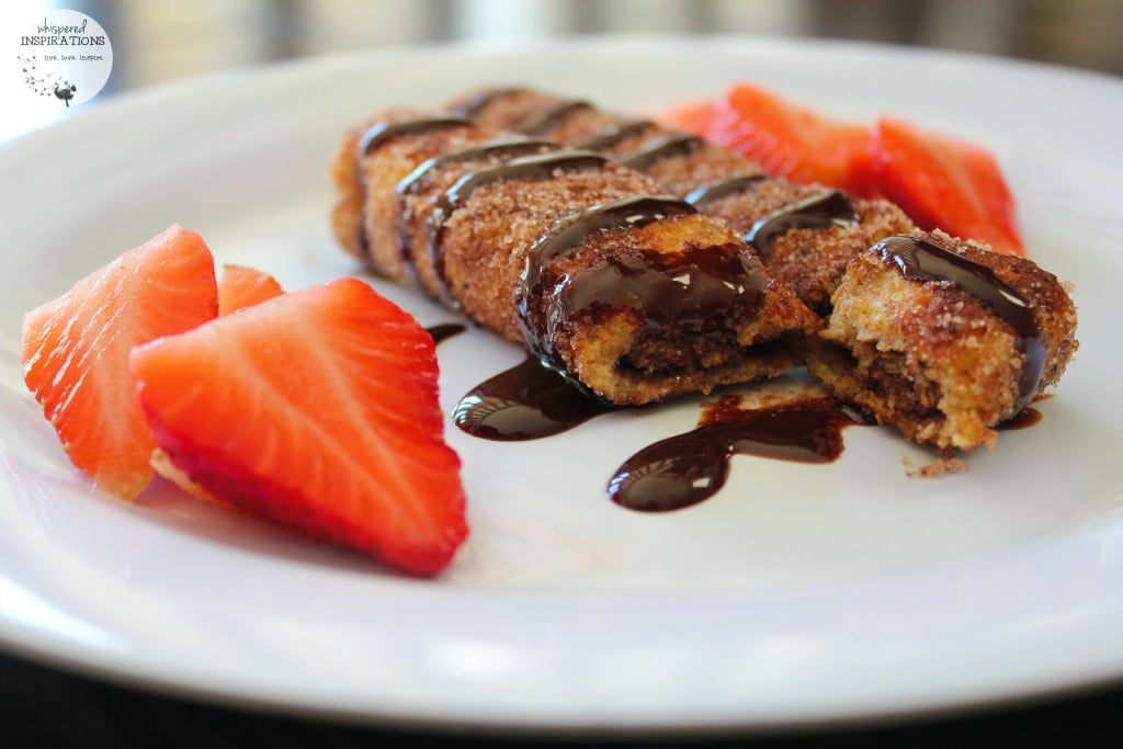 A plate with Nutella churros, topeed with chocolate sauce and served with fresh strawberries. 