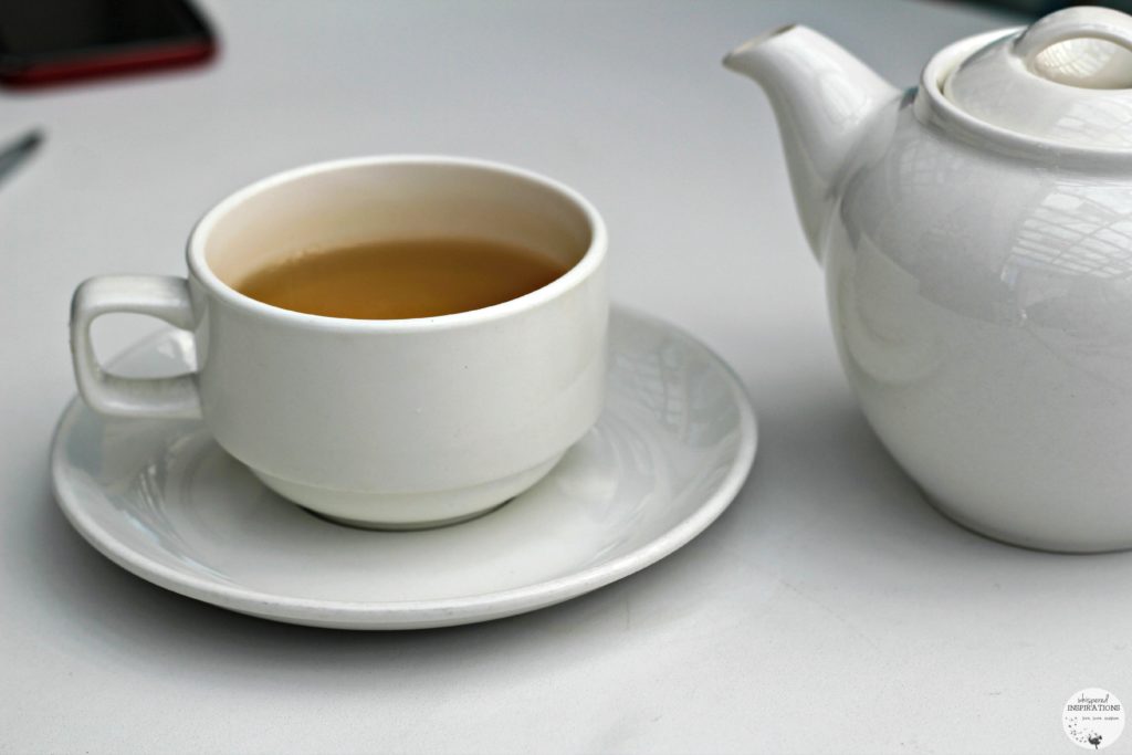 A cup of tea and a tea pot. 