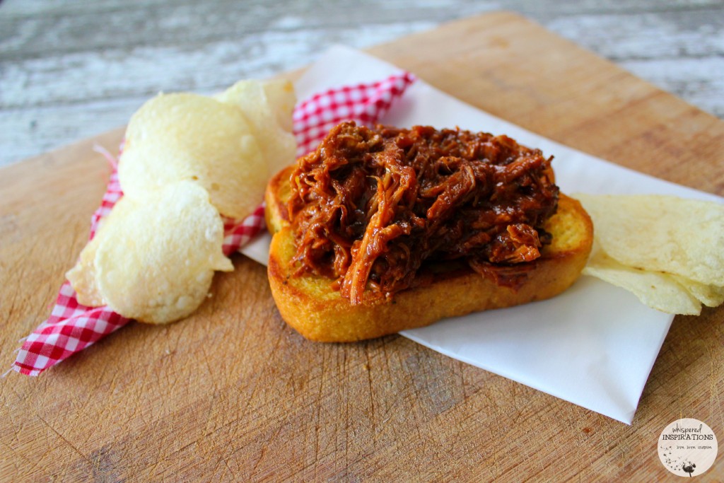 Pulled pork is served on a Texas toast and paired with potato chips.