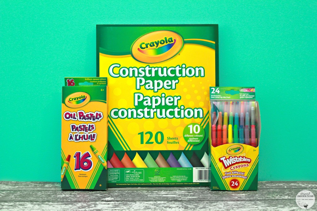 A pad of Crayola construction paper and pencil crayons are displayed.
