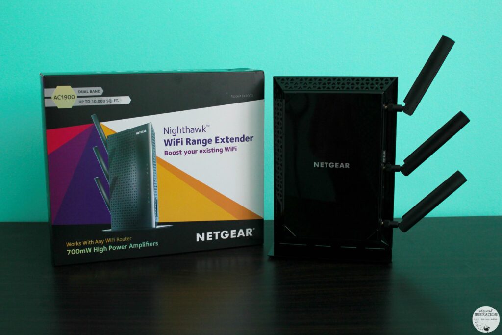 The Nighthawk WiFi Range Extender is pictured outside of the box, it stands next to the box.