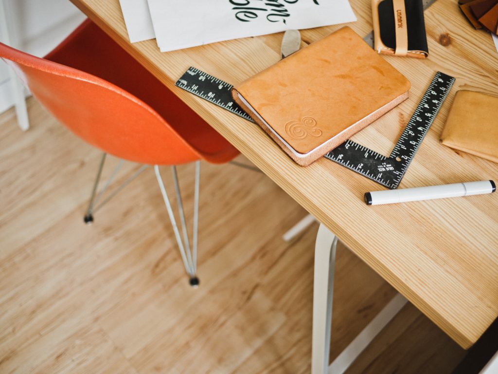 Desk with notebooks, rulers, and pens.