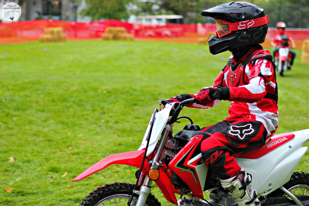 Gabby riding on a dirt bike with helmet and full riding gear on.