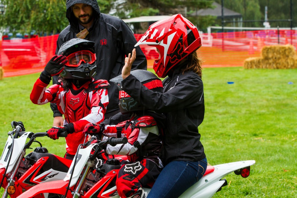 Gabby and Mimi ride on dirt bikes. Mimi is riding with a grown-up. 