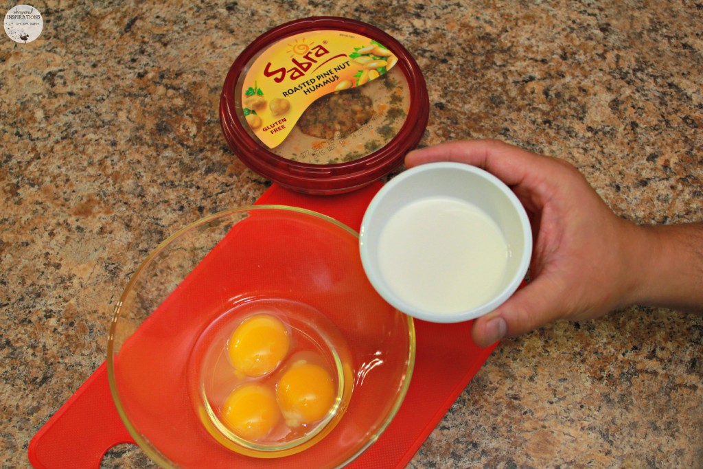 Cream being added to eggs with Sabra hummus on the side. 