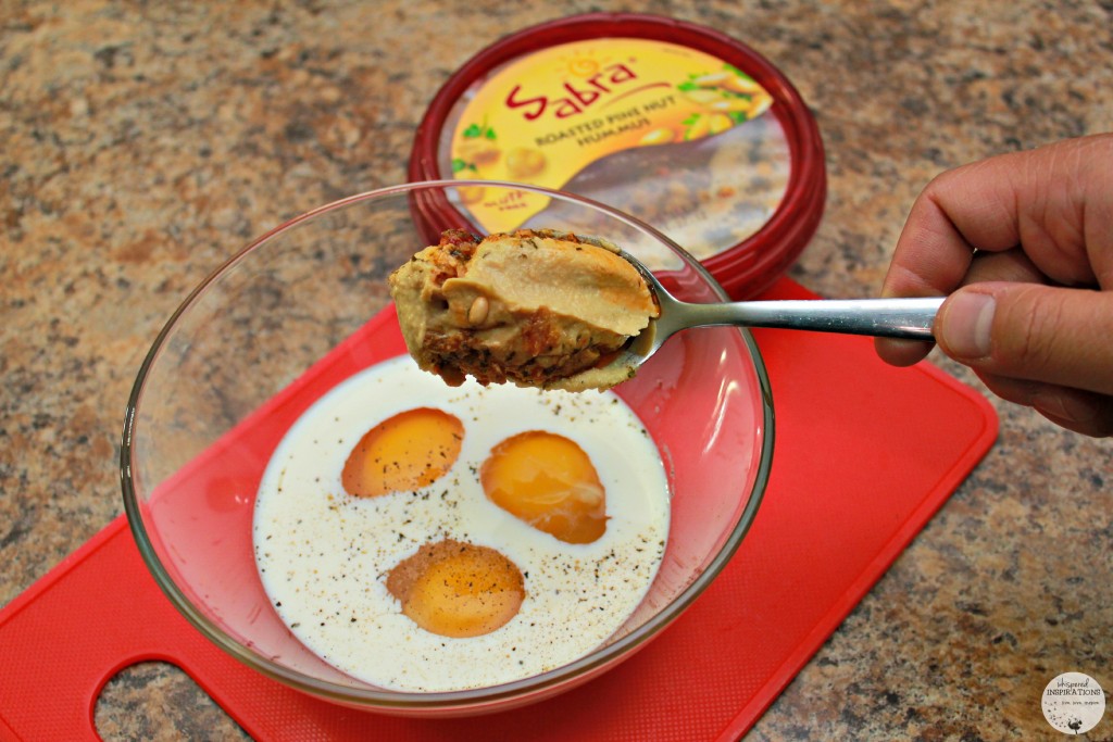 Hummus being spooned into egg mixture.