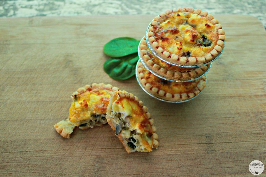 Mini quiches stacked up and one is split in half to show the inside. 