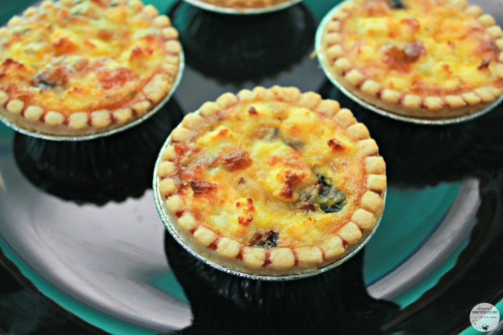 Mini quiches are on a plate, they are golden brown and delicious. 