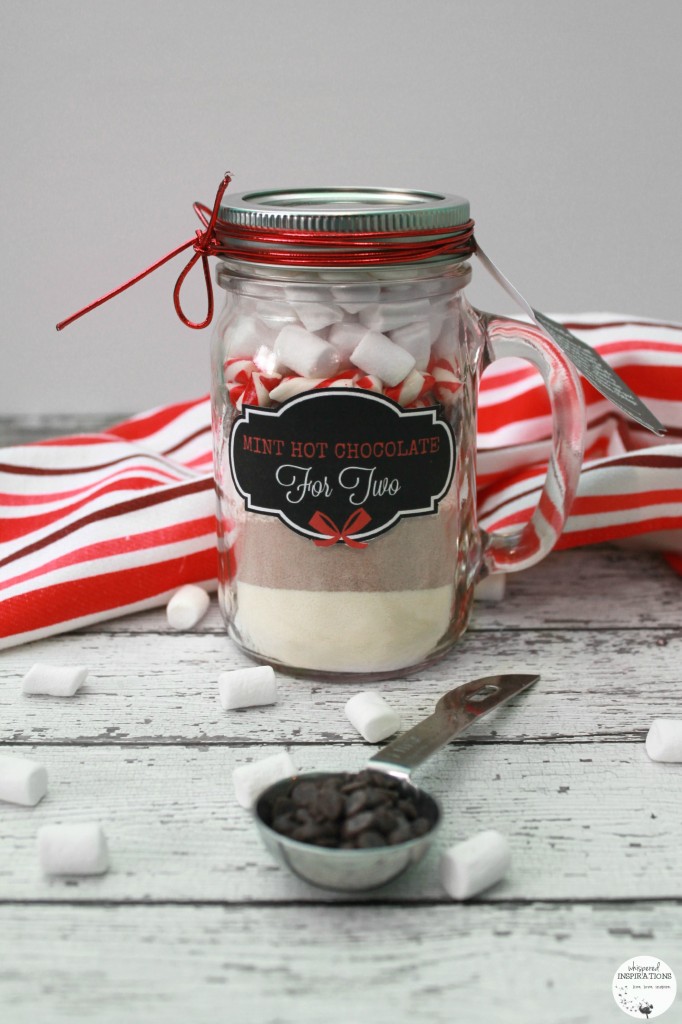 Mint Hot Chocolate in a mason jar as a gift. Layered with creamer, hot chocolate, chocolate chips, candy cane, and marshmallows. 