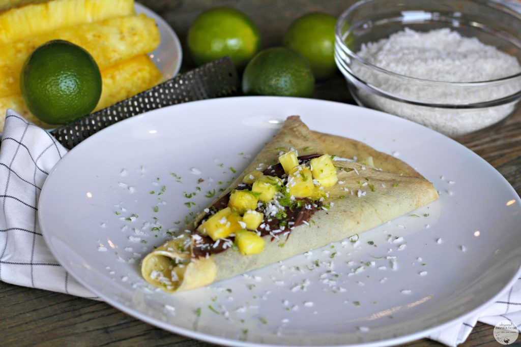 Crepe filled with Nutella, topped with pineapple, lime zest, and shaved coconut..