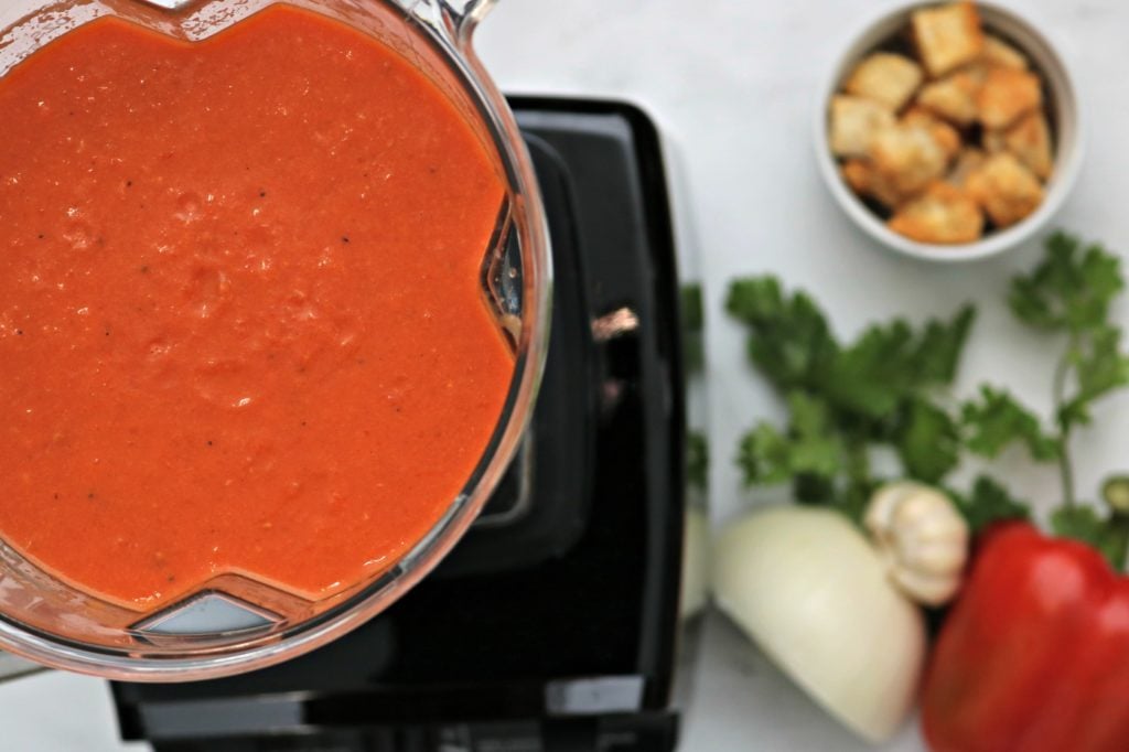 Top view of blended soup ingredients in the Kenmore PRO Heavy Duty Professional Blender. Next to it, you can see the fresh ingredients and croutons. 