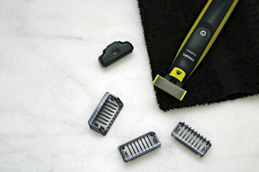 A Philips One Blade on a black towel, with the replacement blades. 