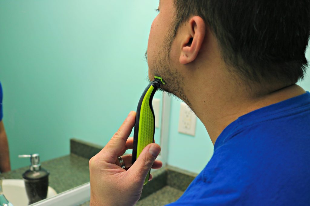 A close up of Darasak shaving with the Philips One Blade. 