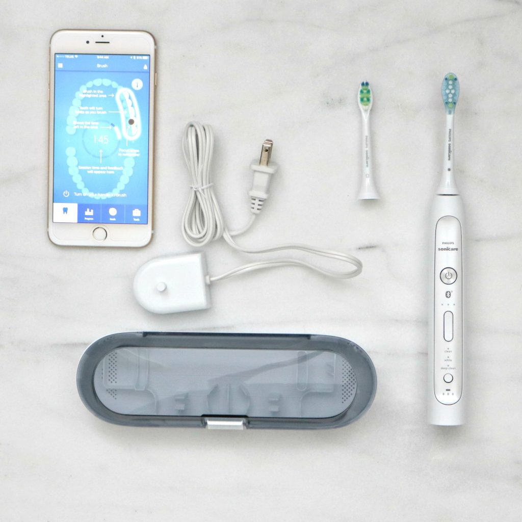 A flat lay with phone and everything that comes in box. All that help with smart brushing with Philips.