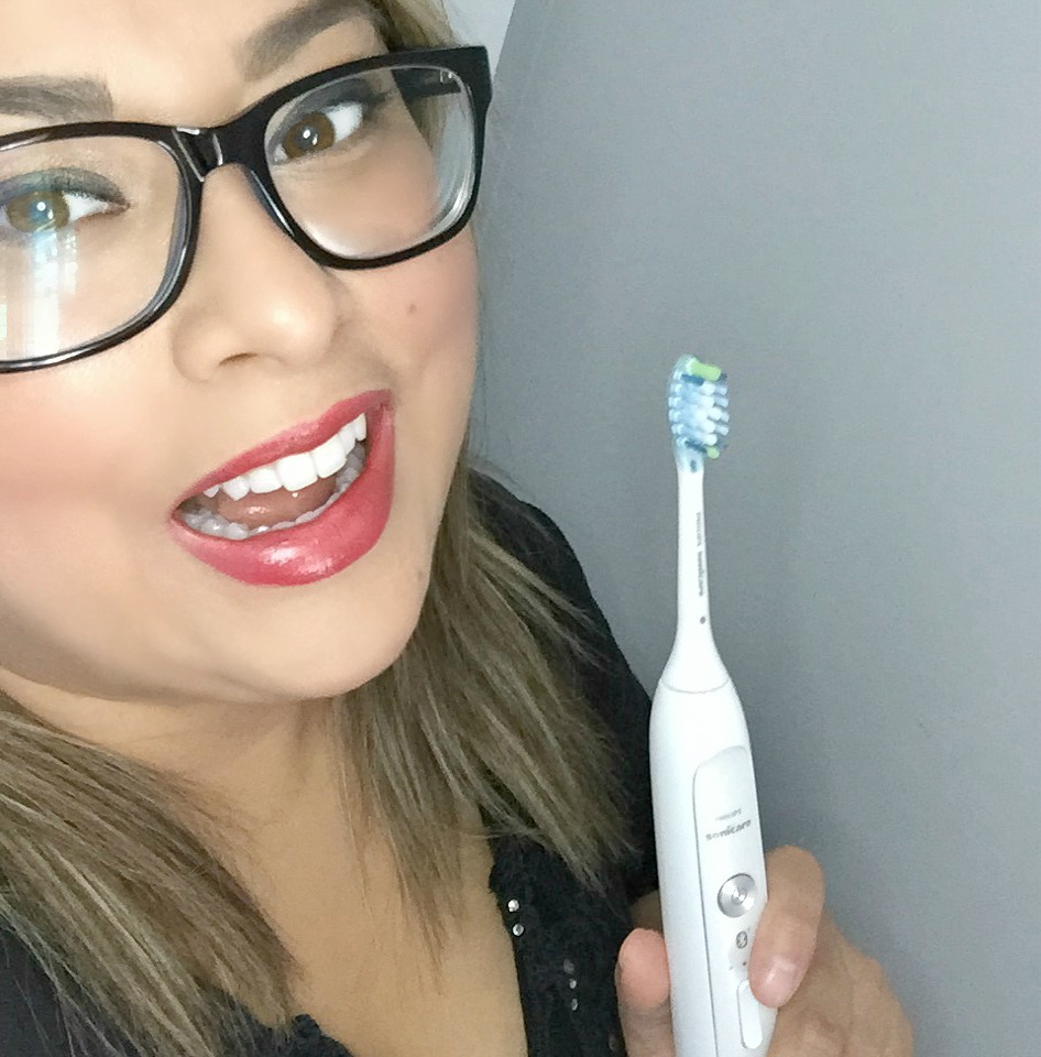 Nancy smiles and laughs while holding her brush. She is smart brushing with Philips.