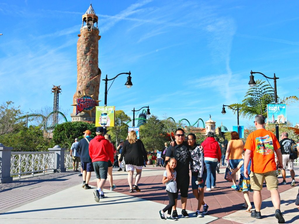 Family stops to pose in front of Island of Adventure tower. 