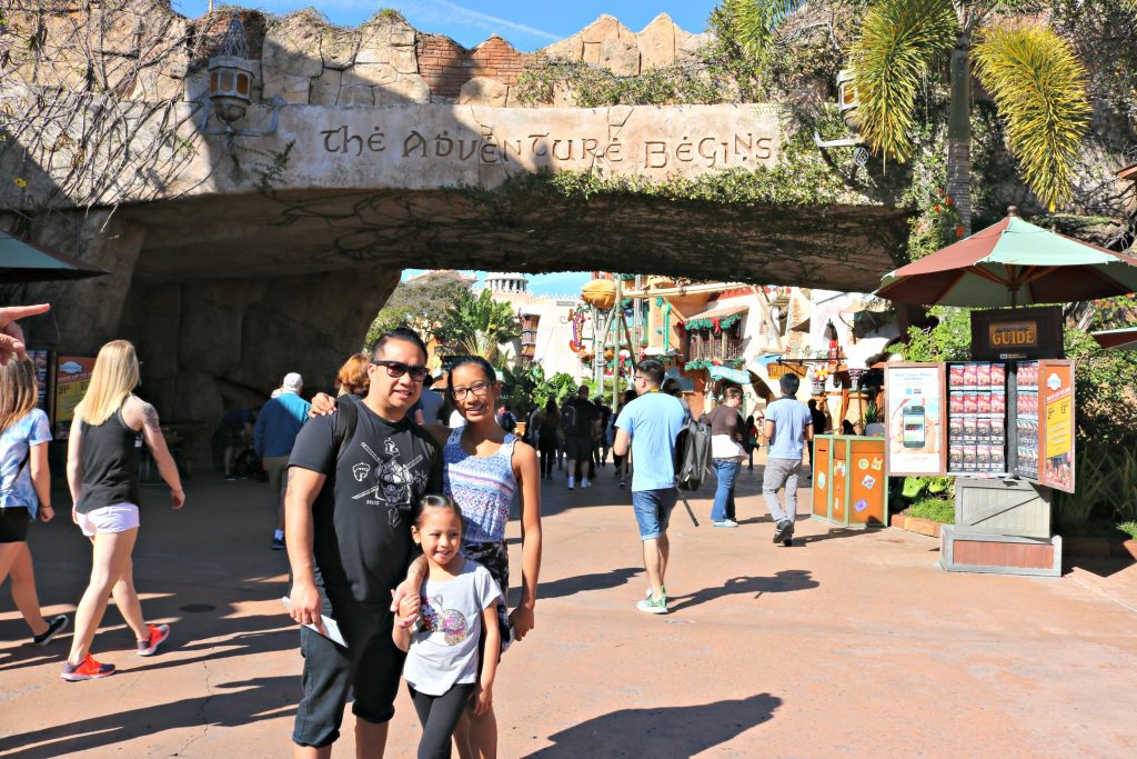 A family poses in front of the entrance of Island of Adventure at Universal Studios. 